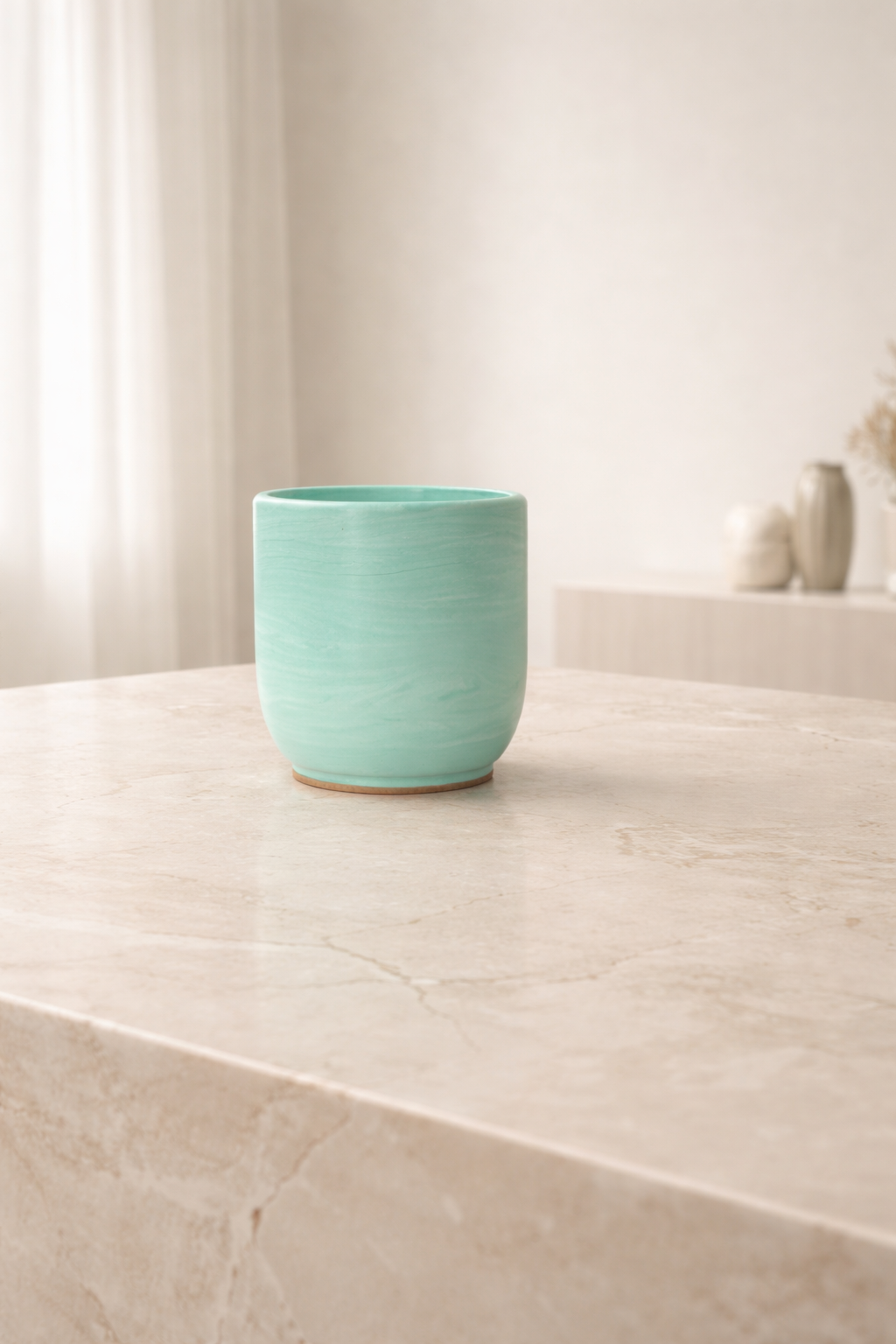 Green Jesmonite candle on a marble surfacebackground